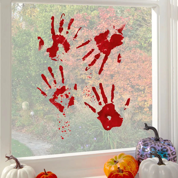 Red bloody handprint decorations on a window with pumpkins in front