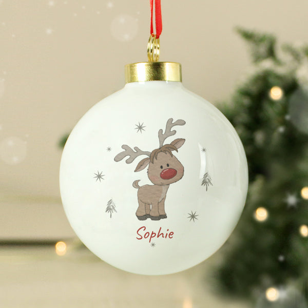 White Christmas ball ornament with a reindeer design and 'Sophie' text, hanging against a festive background.