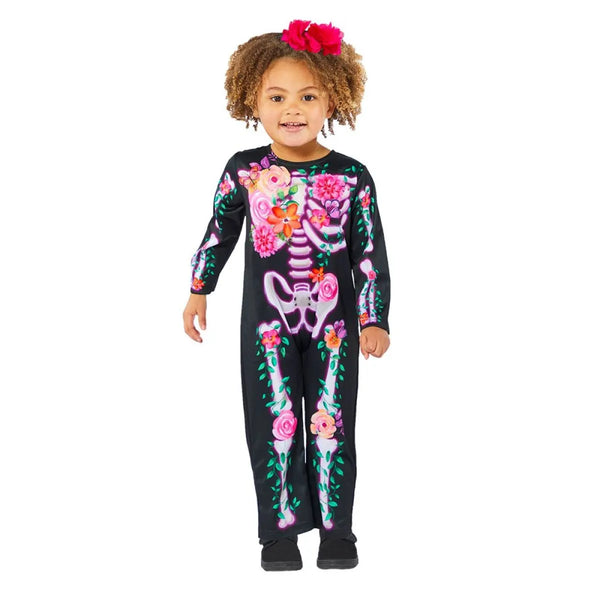 Child wearing a black skeleton-themed onesie with colorful floral designs on a white background