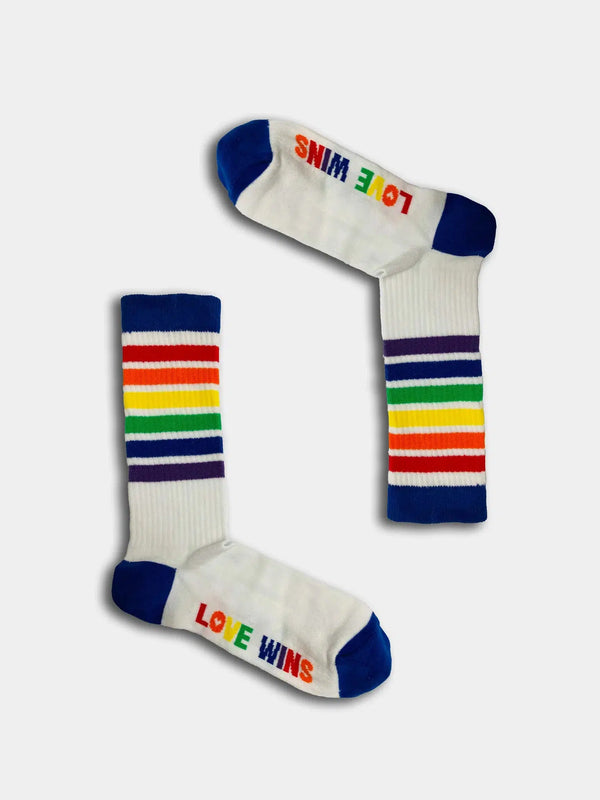 White rainbow socks with text on the sole that reads 