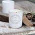 Luxury Merry & Bright Soy Candle Burning On A Wooden Table In Front Of Some Acorns