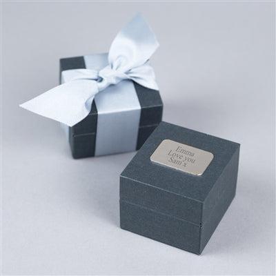 A high quality grey gift box hand-tied with a light-grey grosgrain ribbon personalised with an engraved silver nameplate